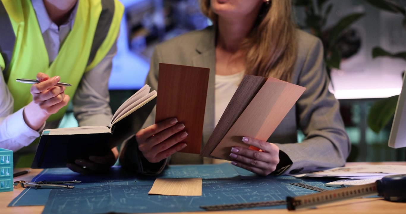 Le donne scelgono i materiali per i pavimenti per futuri appartamenti di lusso.