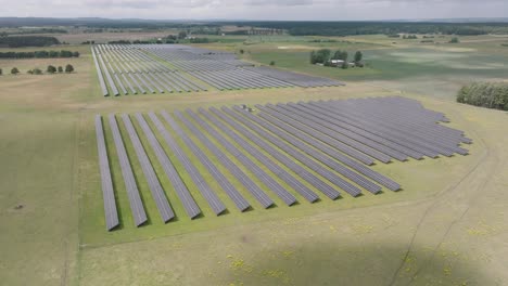 cinematic aerial forward over columns of solar cells in a big energy power plant