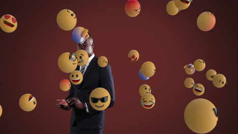 african american businessman using smartphone with emoticons spawning