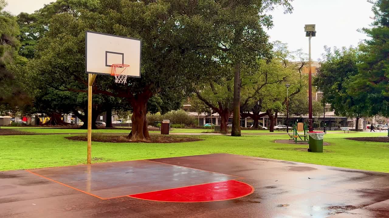 Basketball board and hoop - wide angle on wet court in Weld Square, Perth, Western Australia