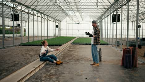 A-loving-couple-of-farmers,-a-girl-with-red-hair-and-her-boyfriend-in-a-cap-have-fun-while-designing-a-new-greenhouse-and-making-their-plans-in-working-on-the-farm