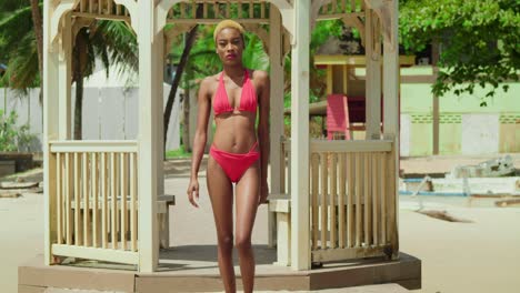 at a caribbean destination, a girl of african descent graces the beach in a vibrant red bikini