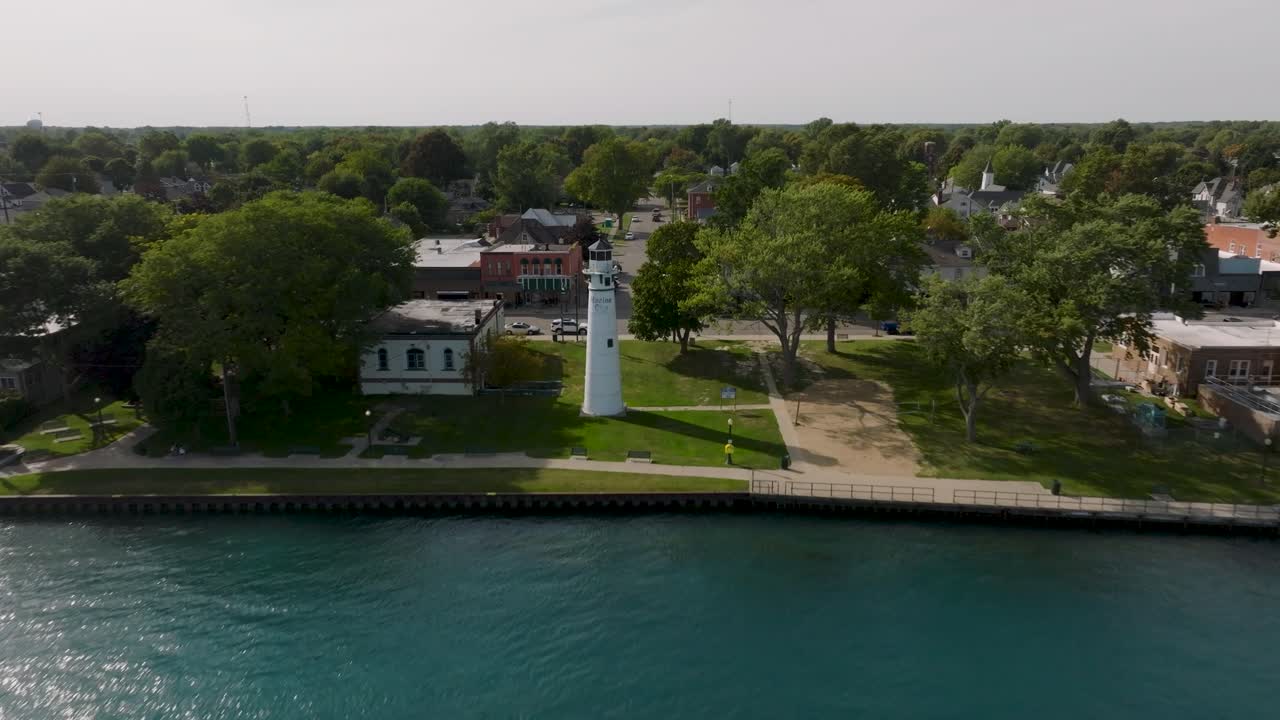 Drone video flying over the Saint Clair River toward the lighthouse in Marine City Michigan showing the shoreline and downtown area