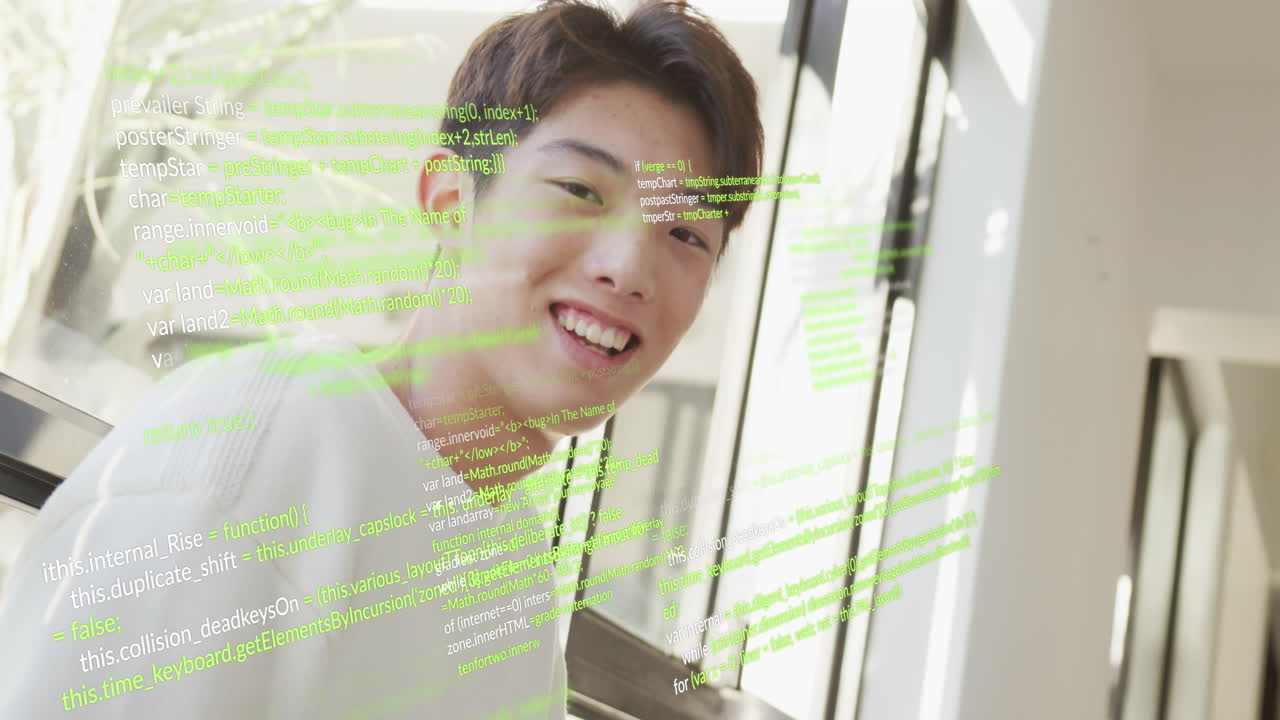 집에서 의자에 앉아 있는 미소 짓는 아시아인 남자 위에 컴퓨터 언어의 애니메이션