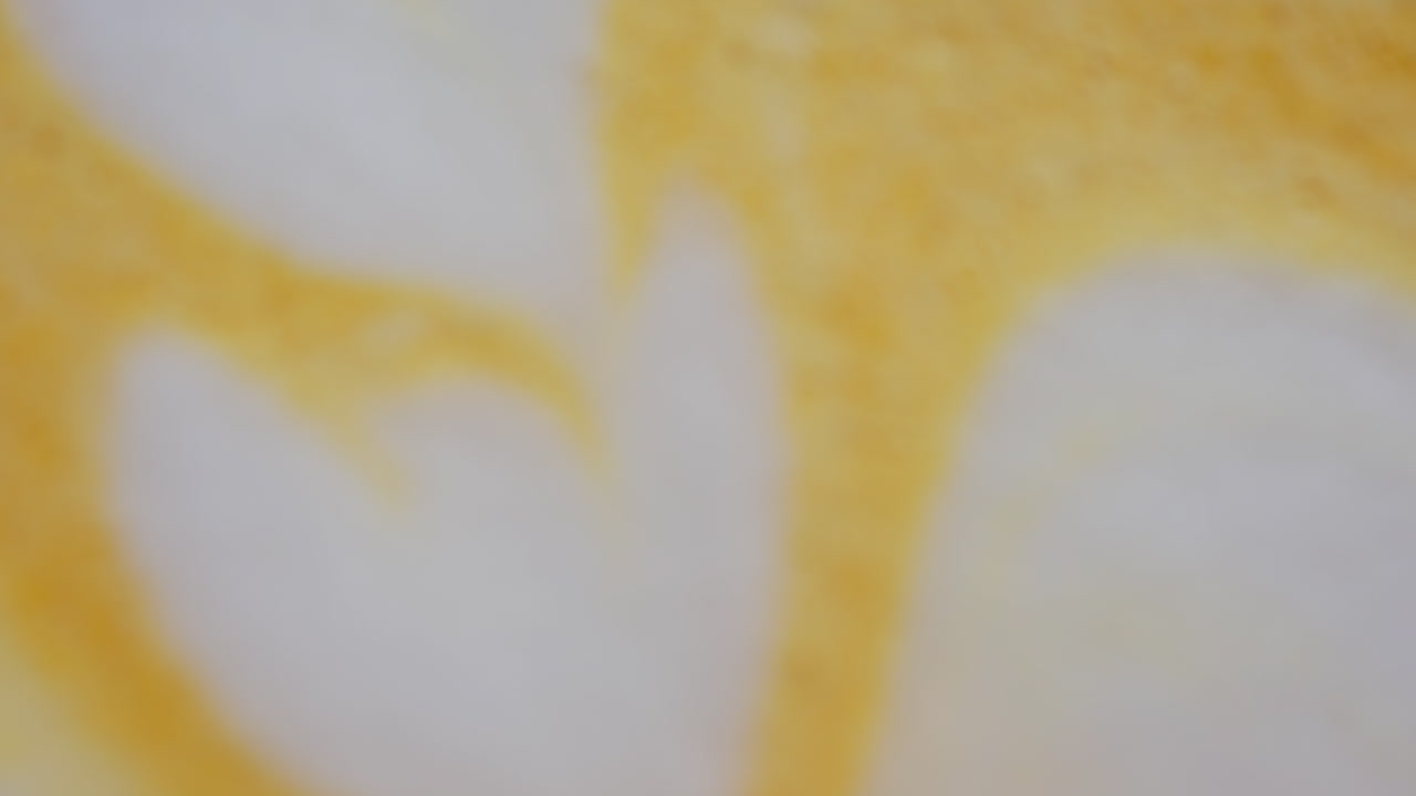 Close up of a heart-shaped latte art in golden turmeric coffee