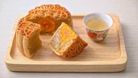 chinese moon cake durian and egg yolk flavour with tea on wood plate