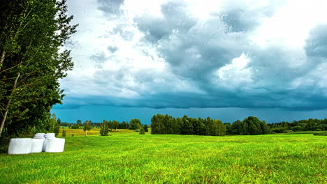 Toma-De-Timelapse-De-Oscuras-Nubes-De-Lluvia-Volando-Sobre-Pastizales-Verdes-Durante-El-Día