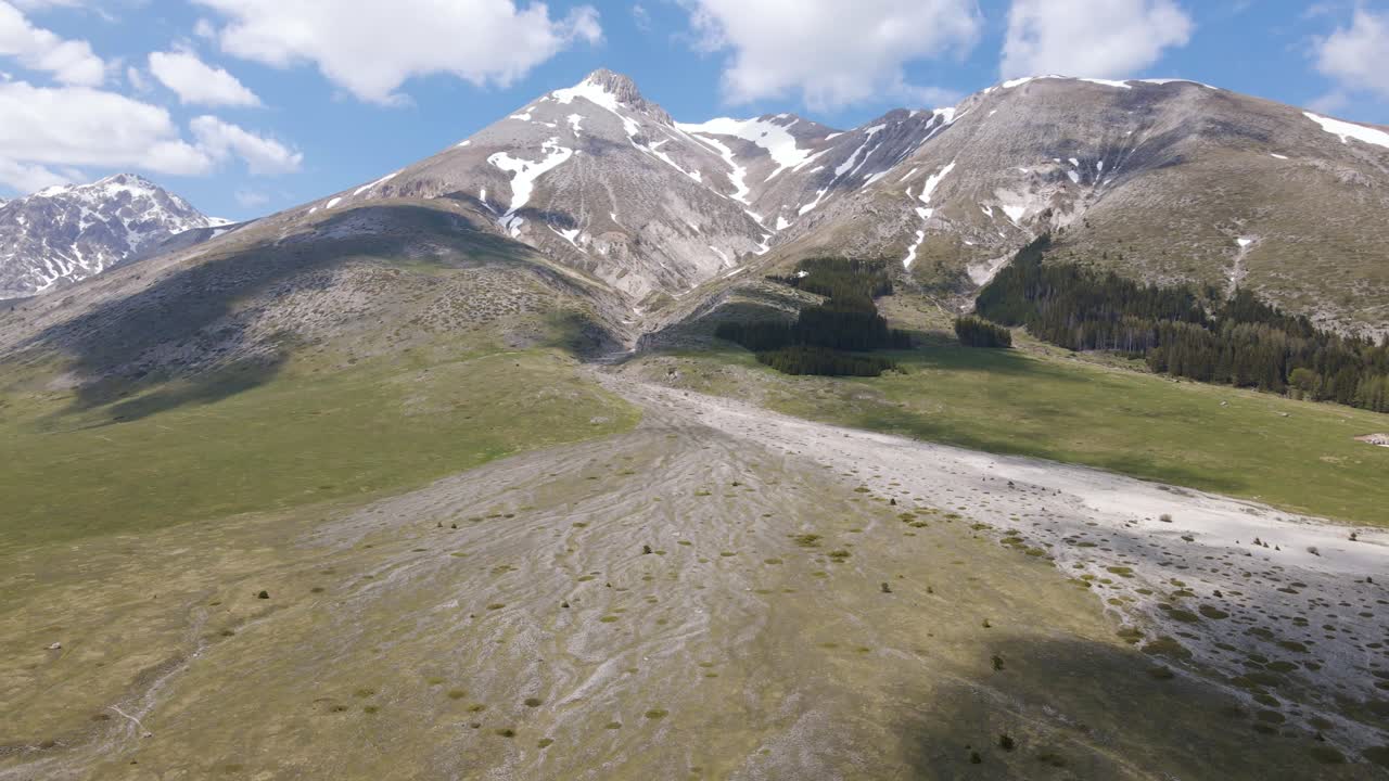 vista aérea de gran angular de las praderas abiertas en un valle con montañas a lo lejos ubicadas en el campo rural de abruzzo en italia