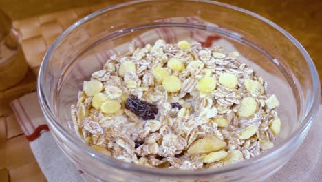 whole grain cereal muesli in a bowl for a morning delicious breakfast with milk. slow motion with rotation tracking shot.