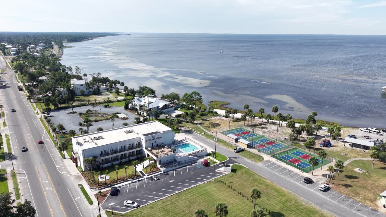 Panorama drone fly of the seaside Port St. Joe town main road with buildings and recreation facilities along the coastline, Gulf County, Florida, USA
