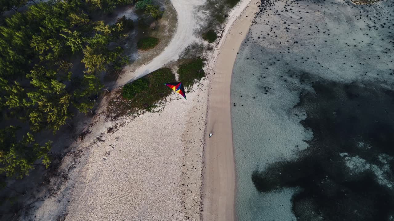 Top-down aerial view of a colorful kite on a sandy peninsula in Mauritius. Concept of freedom, leisure, and tropical travel. Ideal for tourism and lifestyle content