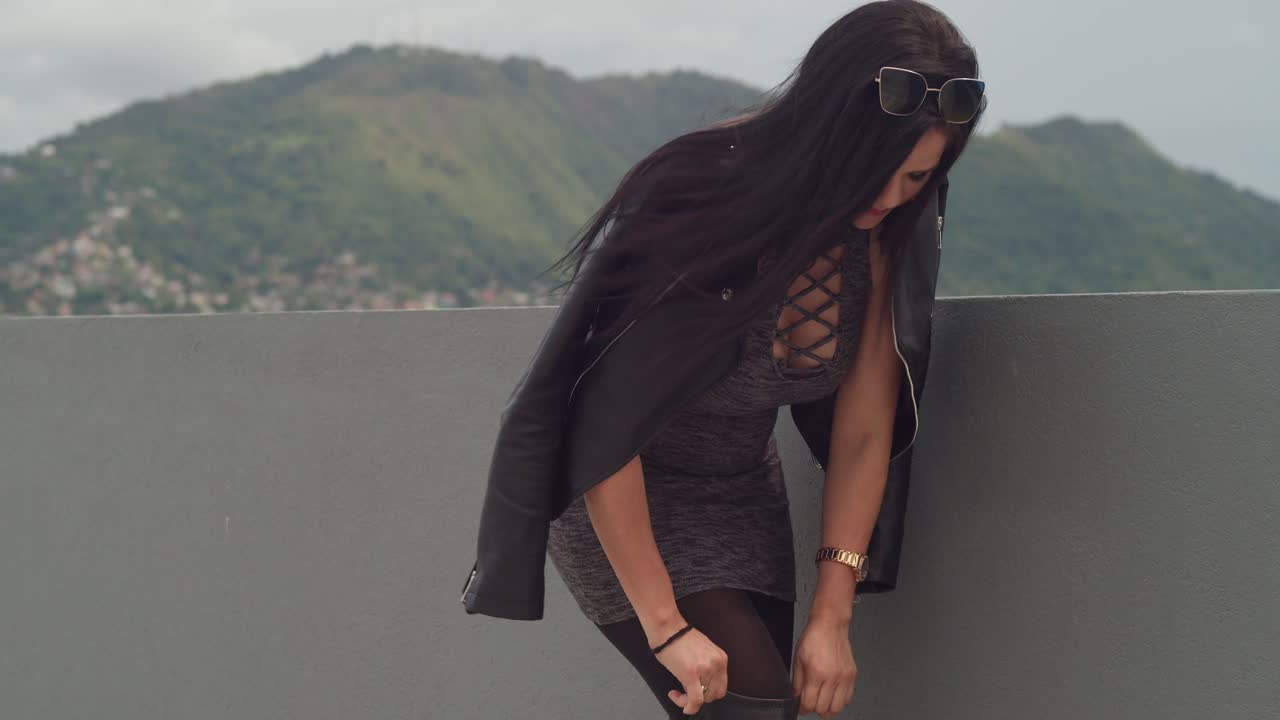 с крыши в порт-оф-спейн, тринидад, женщина наслаждается собой, с горизонтом города на заднем плане