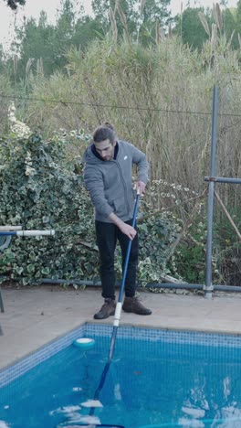 man cleaning a swimming pool
