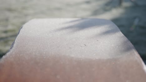 Layer-of-morning-frost-on-wooden-bench