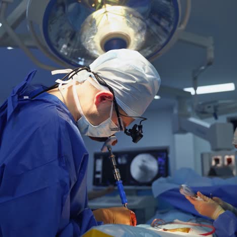 nurse assists surgeon during operation. professional doctor in medical uniform performs a surgery with a sterile surgical instrument in hospital