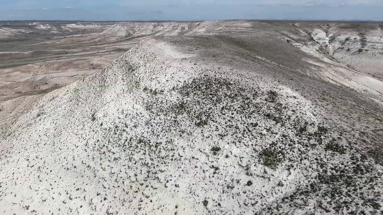 Vista aérea de un vasto paisaje desértico con colinas ondulantes