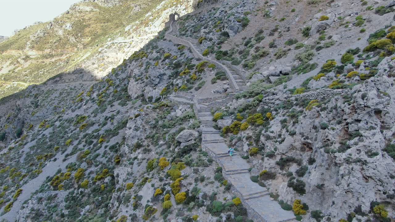 Wide angle dolly in aerial drone shot of beautiful mountains, hills , valleys , roadways, and walkways in west Crete islands, preveli beach during the day