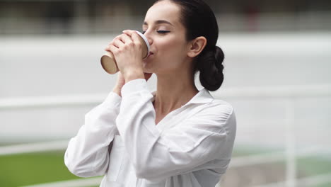 mujer de negocios hablando por teléfono al aire libre. chica bebiendo café en el descanso al aire libre