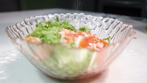 salting salad in bowl