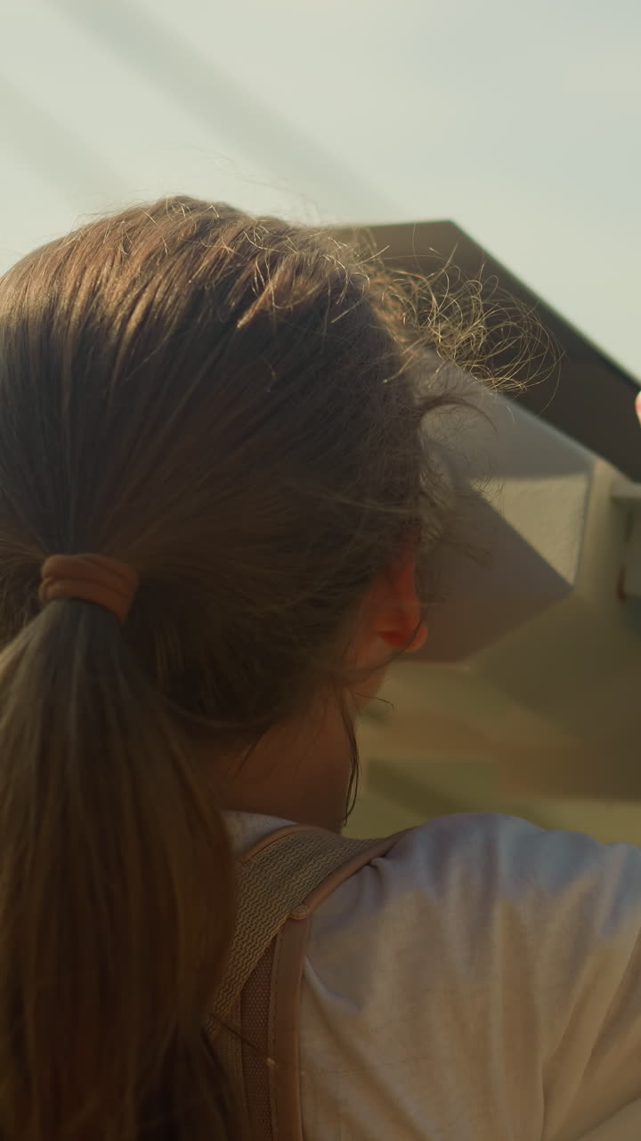 소녀는 산에서 안경을 통해 관광 지역을 조사합니다. 환경의 아름다움과 호기심. 세계 느린 움직임에 관심이있는 유치원