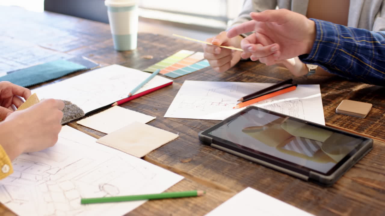 Interior design project, multiracial team using tablet and color swatches, at office