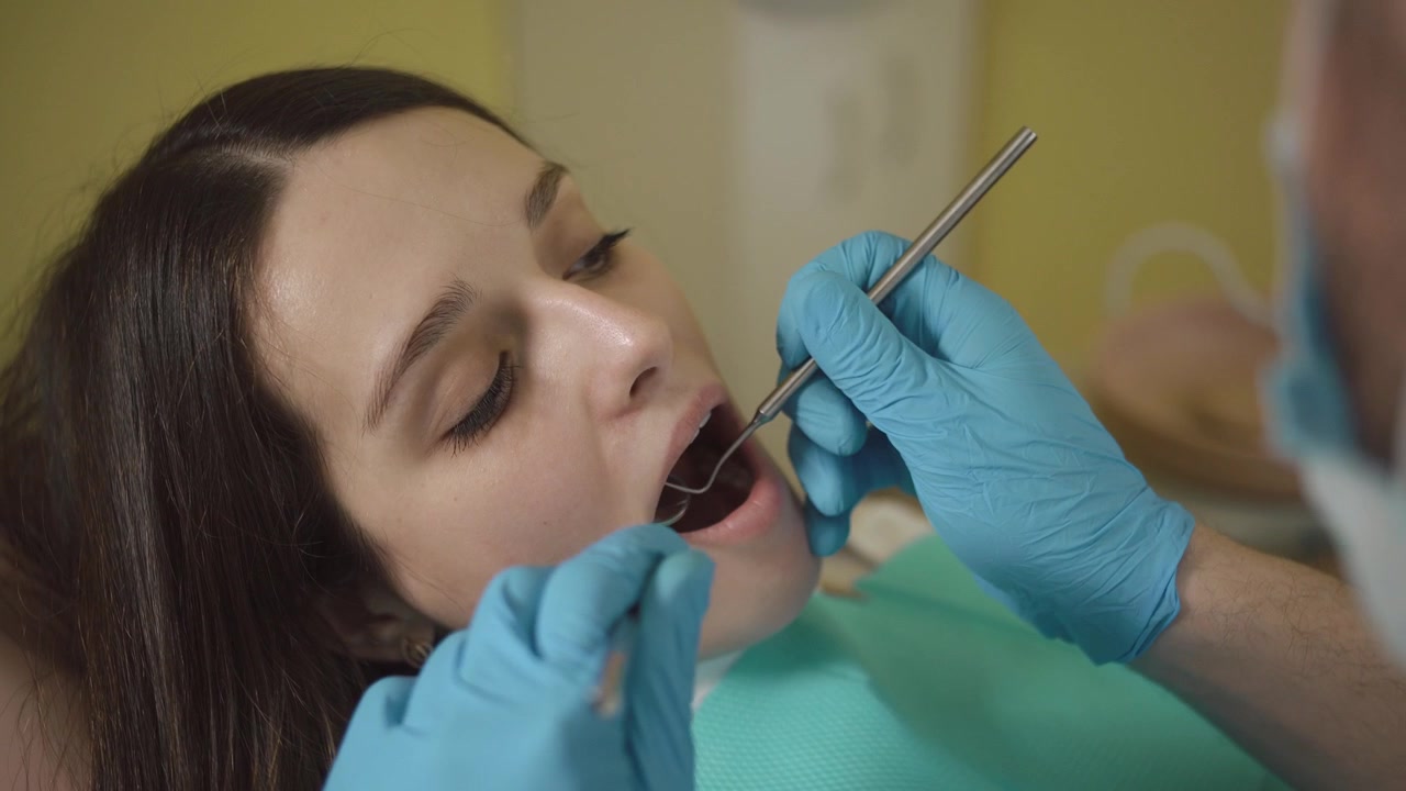 Dentista Examinando os Dentes do Paciente em Clínica Odontológica