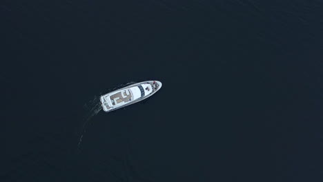 luxury yacht sailing deep water. aerial view of white boat turning around