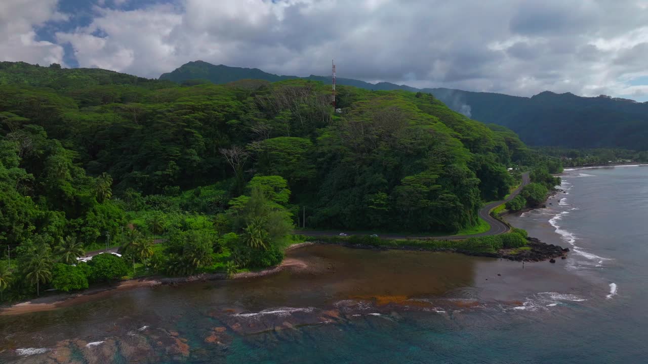 Aerial View of Tropical Coastline with Lush Green Mountains and Winding Road