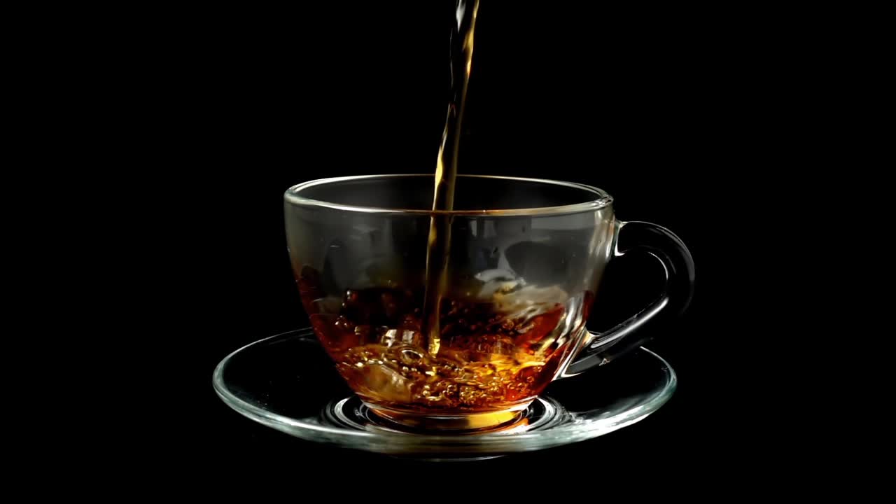 Il tè viene versato nella tazza. Movimento rallentato