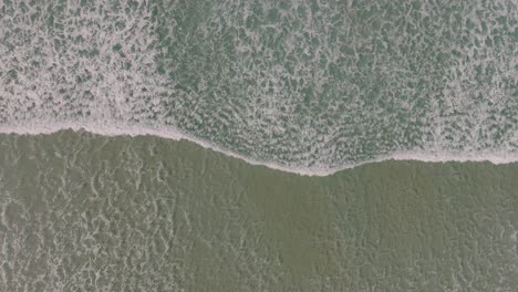 overhead view of waves splashing onto shoreline in razo beach, carballo, spain