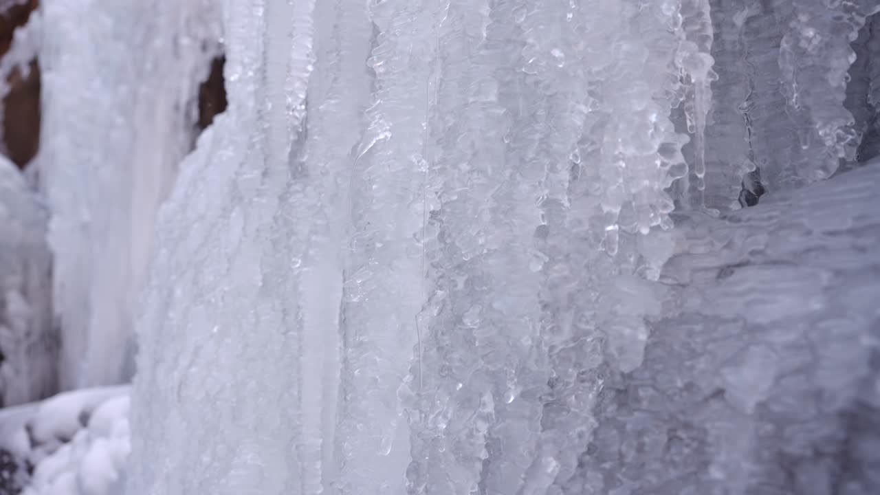 Nel freddo inverno, il fiume si ghiaccia e lunghi blocchi di ghiaccio pendono grondanti d'acqua