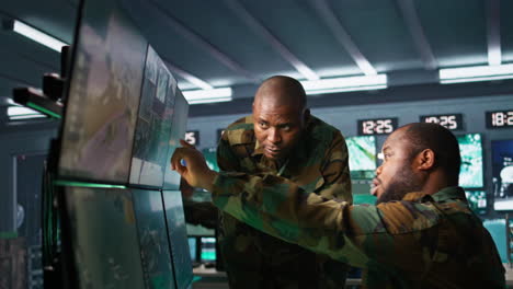 team of soldiers looking at screens in command center