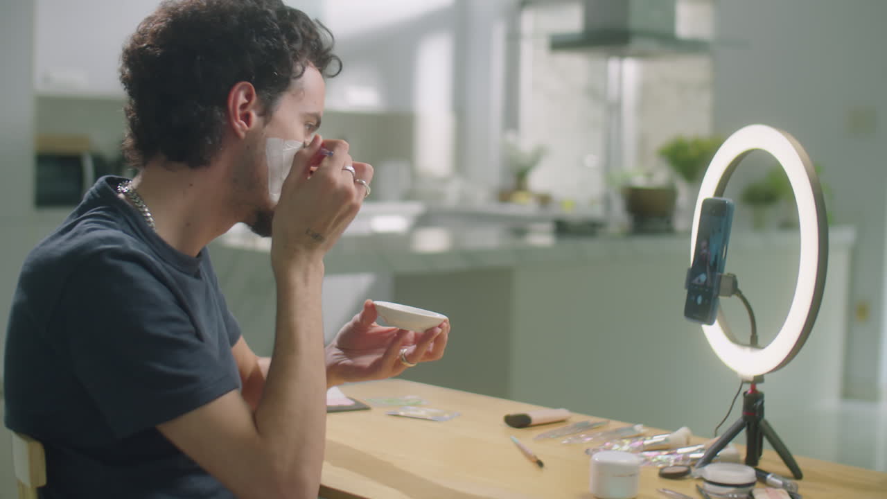 Male Beauty Vlogger Applying Face Mask during Stream