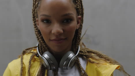 beautiful young mixed race woman with braids listening to music takes of headphones smiling happy enjoying lifestyle