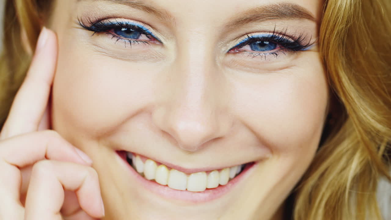 아름다운 젊은 여성이 카메라 문제에 미소를 짓고 손가락으로 얼굴을 쓰다듬어 hd vide