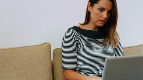 Woman-using-laptop-in-living-room