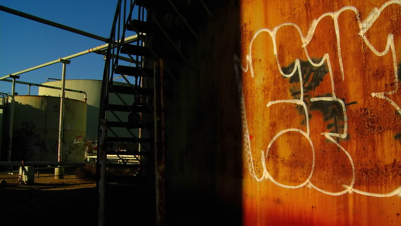 공업 지역의 그림자 속으로 들어가는 낙서로 뒤덮인 벽의 시간 경과