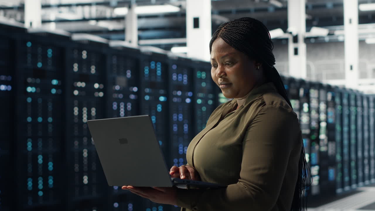 Engineer using laptop in data center, integrating new technologies
