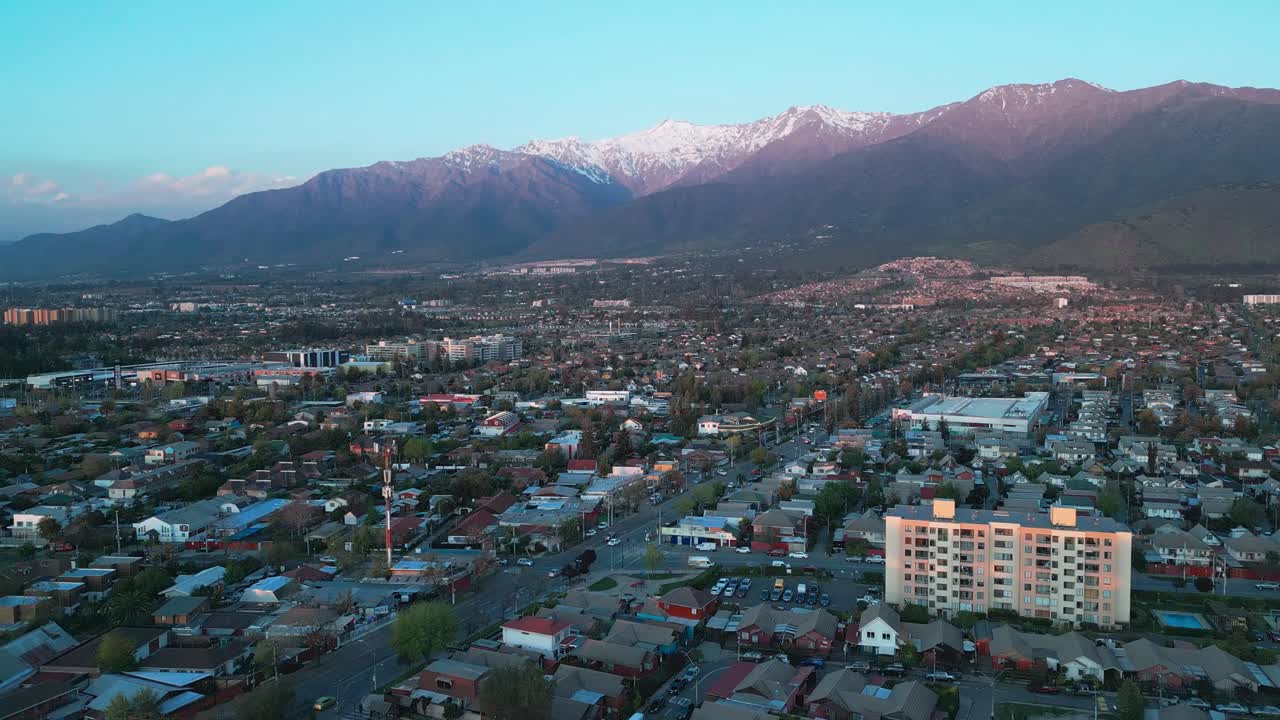 Vista aerea di quartieri residenziali con case e condomini che si estendono verso le Ande innevate al crepuscolo. La Florida, Santiago, Cile