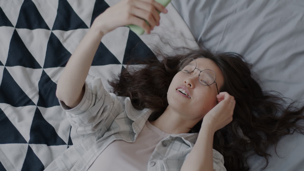 침대에서 셀피를 찍는 여자