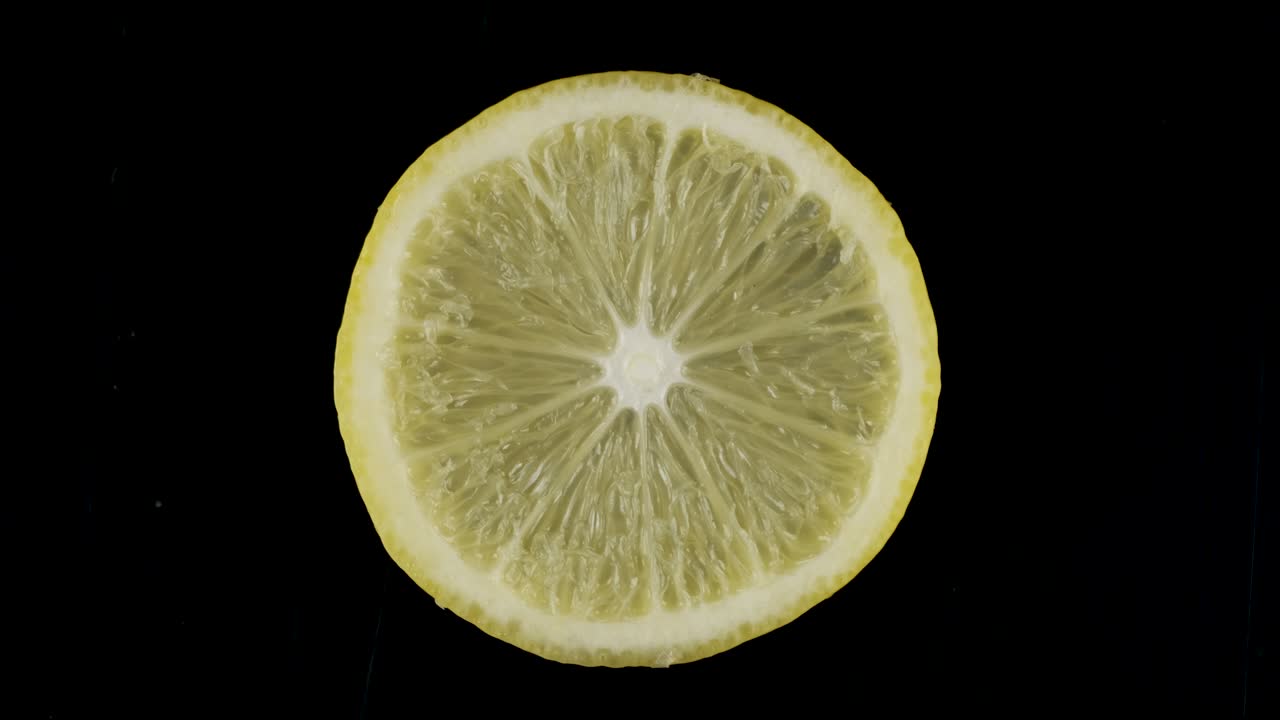 rotación de una rebanada de limón sobre un fondo negro.