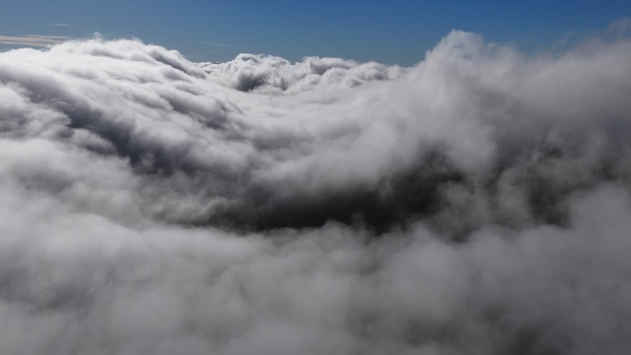 Aerial reveal from inside the clouds on a sunny morning