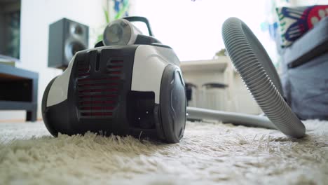 man retracting the power cord of a vacuum cleaner