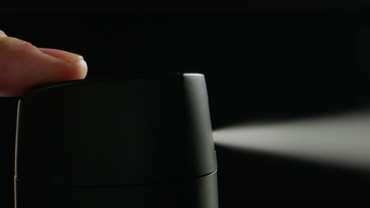 Young man applying perfume to skin in the dark, close up of spraying deodorant luxury perfume.