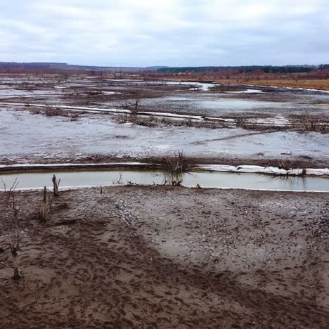 Nature in danger. Drought on earth. Narrow stream of dirty water of dried lake. Climate change. Ecological disaster. Environmental pollution. Motion camera back