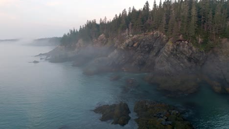 breathtaking slow push through morning fog reveals maine's coastal cliffs