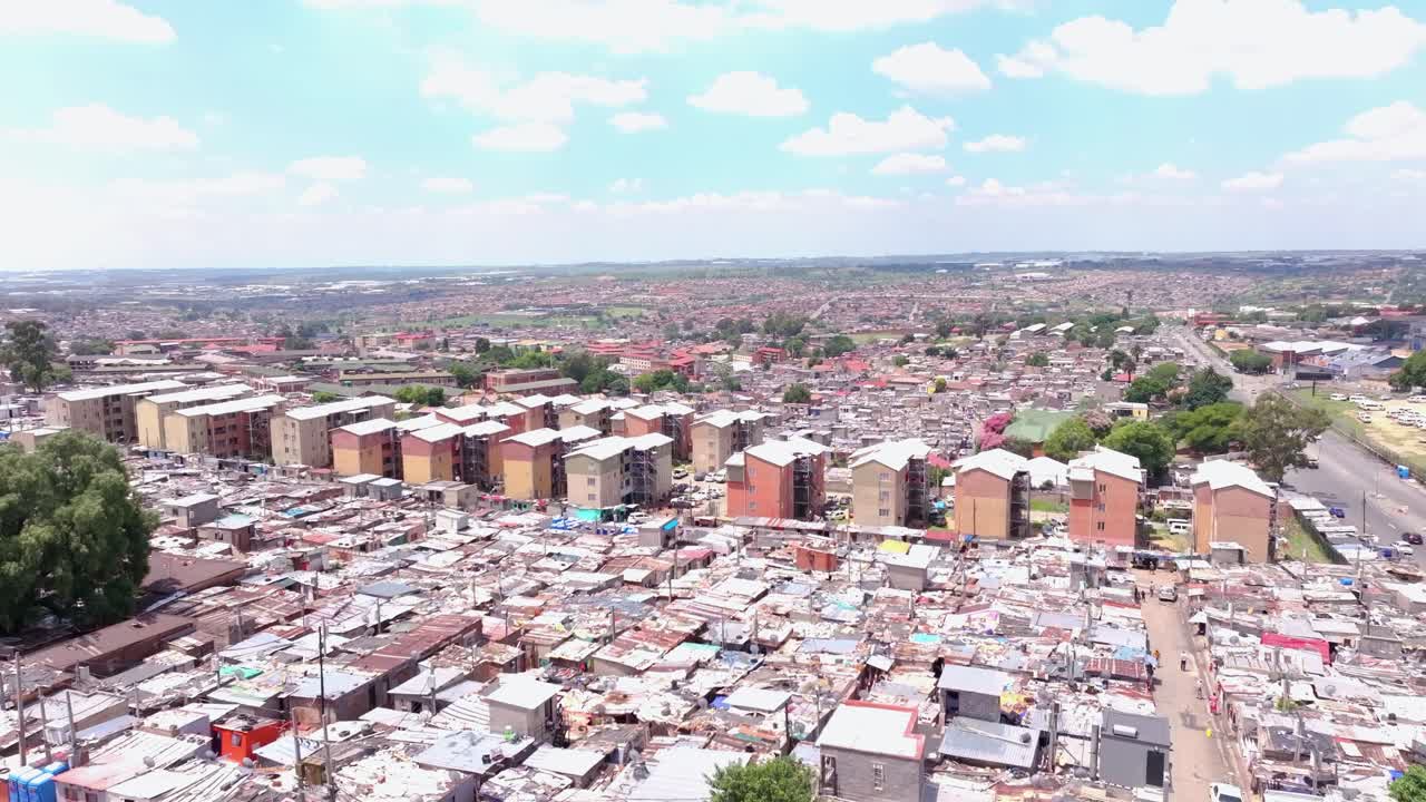Aerial boom shot revealing Alexandra Township, Johannesburg, South Africa, on a sunny day with scattered clouds