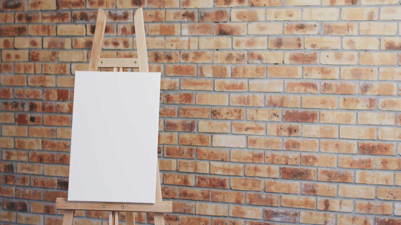 Video of white canvas sign on wooden easel with copy space on brick wall background