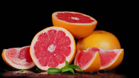 trozos de pomelo fresco con hojas girando lentamente.