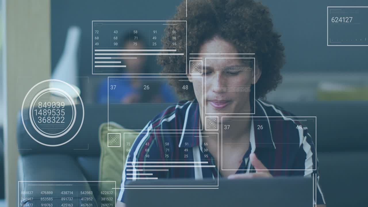Man sitting on sofa reviewing laptop for tech analysis while receiving HUD charts and numeric grids